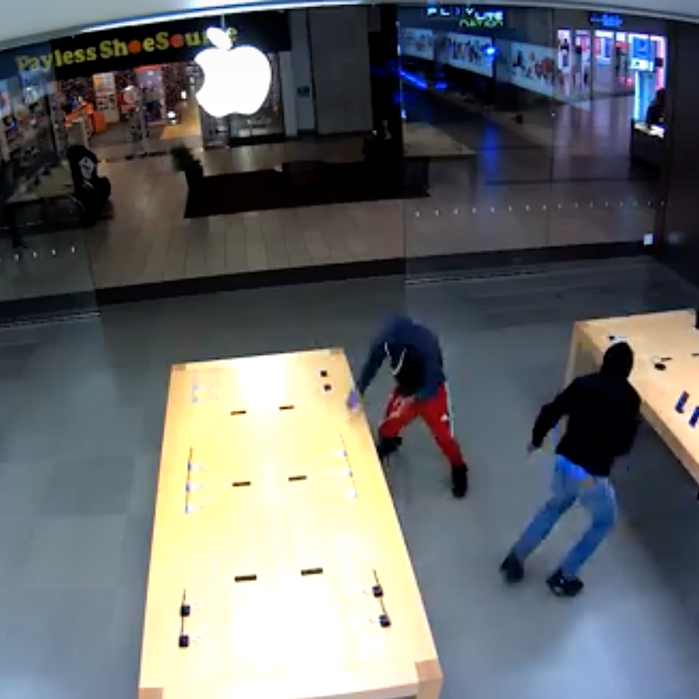 A screen grab of security footage showing robbers enter an Apple store in Santa Rosa, Calif., and steal multiple Apple devices.