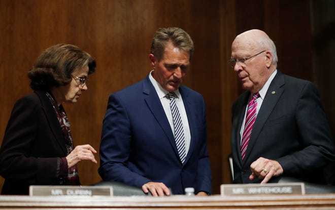 Sen. Jeff Flake, R-Ariz., center, talks to Sen. Dianne Feinstein, D-Calif, left, and Sen. Patrick Leahy, D-Vt., during a delay in the Senate Judiciary Committee hearing, Friday, Aug. 28, 2018 on Capitol Hill in Washington.  (AP Photo/Pablo Martinez Monsivais) ORG XMIT: DCPM202