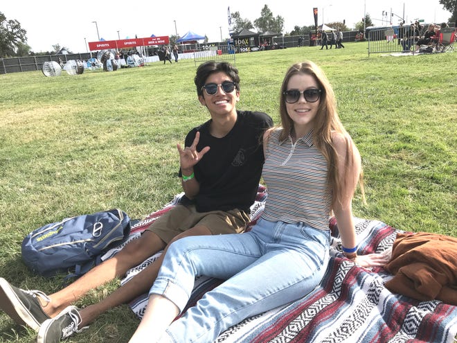 Awolnation fans Julian Christie, left, and Erin Caldwell sit on the Redding Civic Auditorium lawn Saturday afternoon before the start of the Redd Sun music festival.