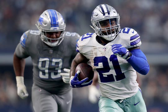 Cowboys running back Ezekiel Elliott carries the ball to score a touchdown against Lions defensive lineman Da'Shawn Hand in the second quarter in Arlington, Texas, Sunday, Sept. 30, 2018.