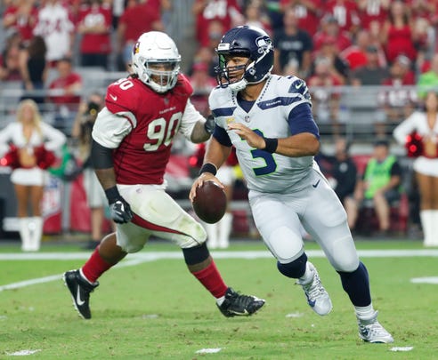 Seattle Seahawks quarterback Russell Wilson (3) scrambles away from Arizona Cardinals defensive tackle Robert Nkemdiche (90) during the second quarter at State Farm Stadium in Glendale, Ariz. September 30, 2018.
