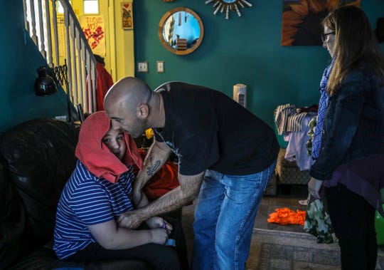 Charlie Kondek, of Northville helps his son, Samuel, who is autistic, get up from the couch as his wife Laurie looks on at their home on Friday, Sept. 28, 2019.