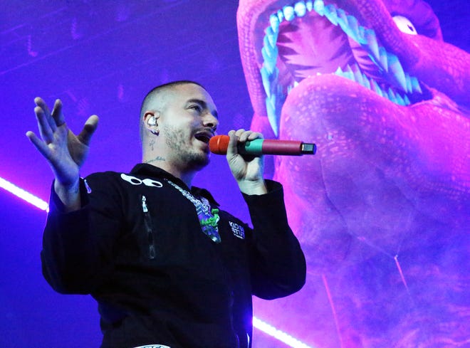 Reggaeton singer J Balvin is surrounded by dinosaurs on stage during his Sunday night show at the Don Haskins Center.