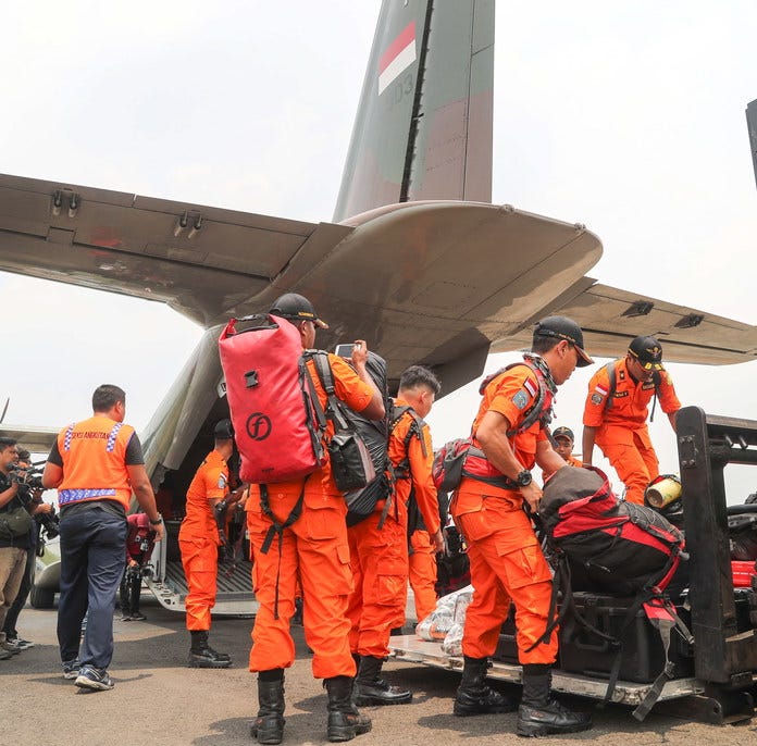 Members of the Indonesian National Search and Rescue Agency prepare their gear inside a military base before being transported to the disaster area after a 7.7 magnitude earthquake that hit Central Sulawesi.