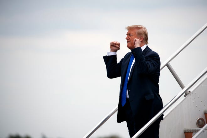 President Donald Trump pumps his fist towards supporters as he steps off Air Force One after arriving at Philadelphia International Airport, Tuesday, Oct. 2, 2018, in Philadelphia. (AP Photo/Evan Vucci)
