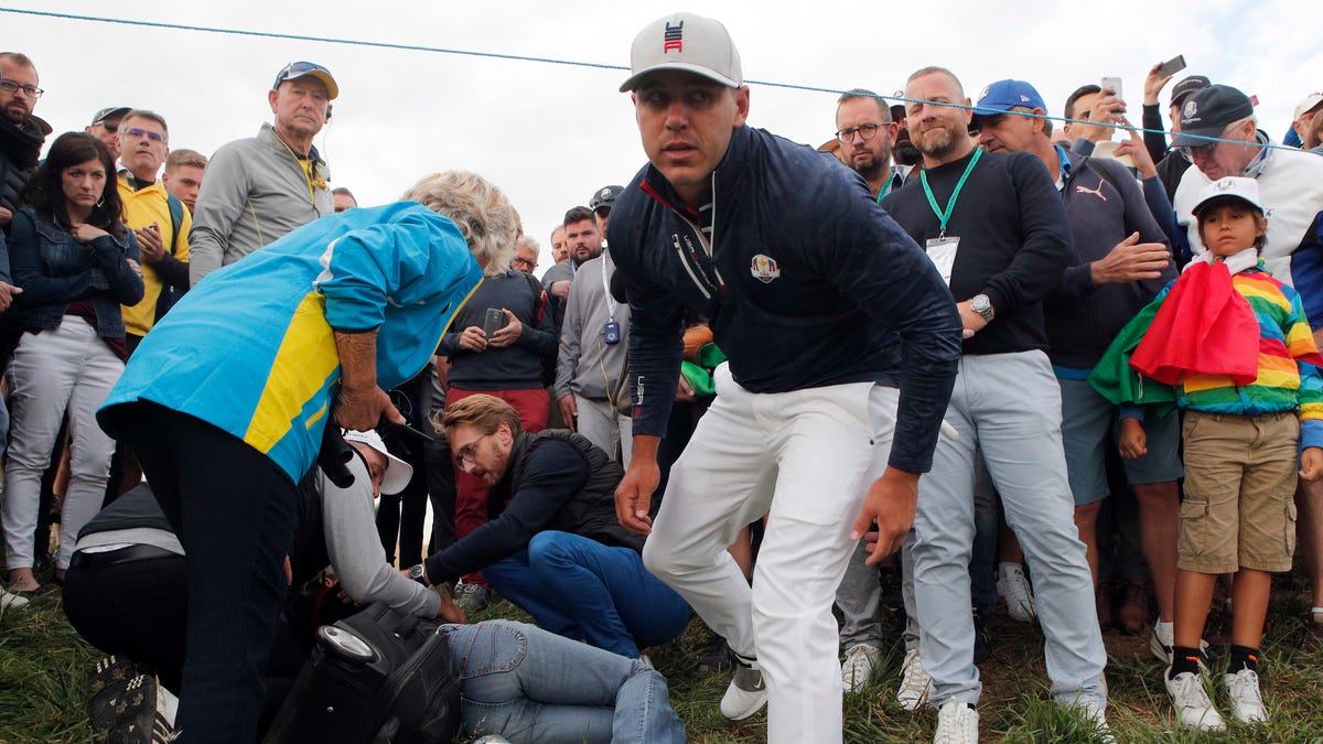 Brooks Koepka offers a golf glove to a spectator he injured when his ball hit her on the sixth hole during his fourball match on the opening day of the 42nd Ryder Cup at Le Golf National in Saint-Quentin-en-Yvelines, Paris.