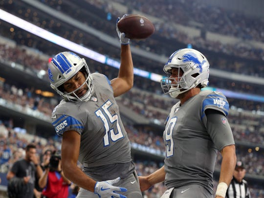 Golden Tate spikes the ball while celebrating his fourth-quarter touchdown Sunday with Matthew Stafford.