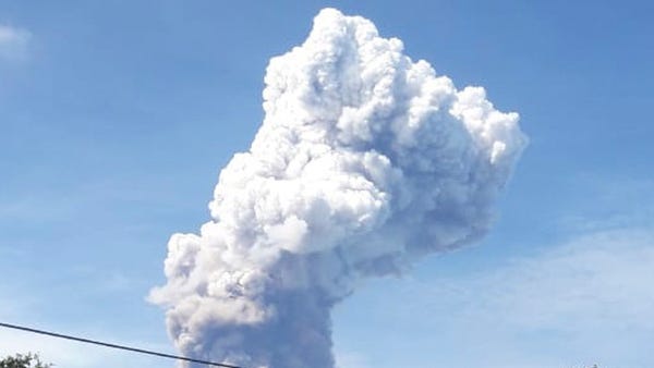 Plumes of volcanic ash rise out of Mount Soputan...
