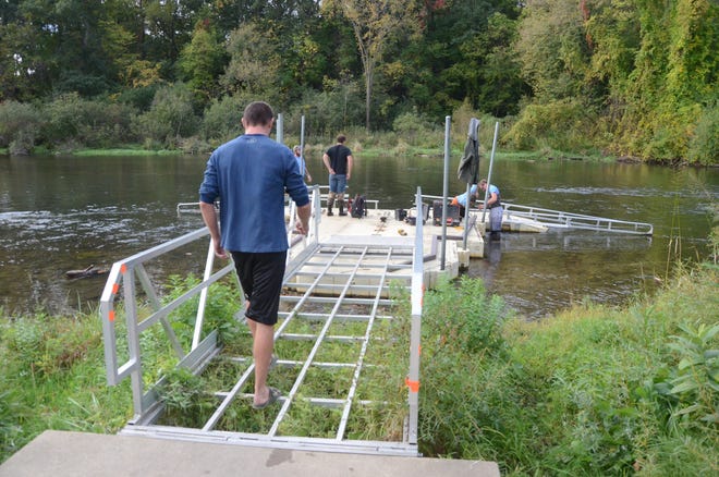 Tom Lewis, left, of Dock Masters in Richland, steps over open areas of the deck Thursday after materials were stolen from the kayak launch at Historic Bridge Park.
