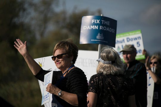 Donna Klinefelter of Kewadin joins a group of supporters of the Democratic Party as they stand along U.S. 31 in Elk Rapids on Monday, Sept. 24, 2018.
