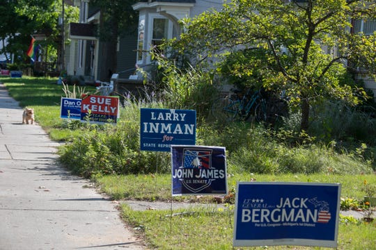 Democrat and Republican signs sit juxtaposed in yards in a Traverse City neighborhood on Monday, Sept. 24, 2018.