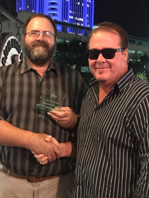 Jeff Cumming, right, president of MAMA, presents the 2018 MVP award to Montgomery Advertiser entertainment writer Shannon Heupel.