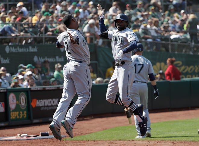 Dee Gordon, right, and Jean Segura celebrated a win over the Oakland A's sin August. The two allegedly scuffled in the clubhouse on another occasion, leading to questions about the Mariners' team chemistry during its late-season slide.
