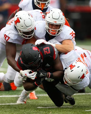Rutgers Scarlet Knights running back Jonathan Hilliman (23) is stopped for a loss by Illinois Fighting Illini defensive lineman Bobby Roundtree (97), linebacker Jake Hansen (35) and linebacker Dele Harding (9) during first half at High Point Solutions Stadium.