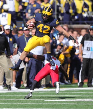 Michigan's Ben Mason jumps over Maryland's Marcus Lewis during the first quarter Saturday, Oct. 6, 2018 at Michigan Stadium in Ann Arbor.