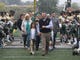 Former St. Joseph Coach, Tony Karcich walks through a line of St. Joseph players as part of a ceremony honoring Karcich and naming the St. Joseph field after him.