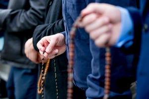 People hold rosaries during a Rosary Coast to Coast event on the Detroit River waterfront.
