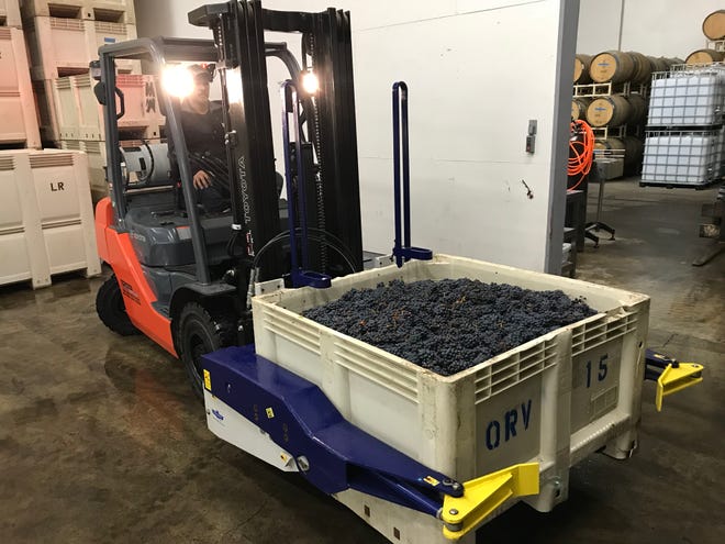 Workers from Laurel Ridge Winery stack Laurel Ridge bins of grapes they received from Southern Oregon growers Friday night, October 5, 2018. The 17 bins of the fruit were rejected by a California winery due to smoke taint.
