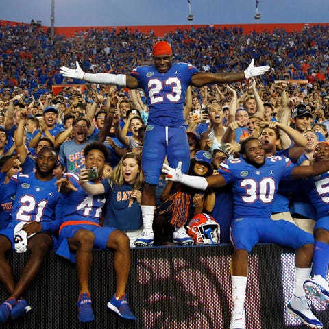 Florida players celebrate with fans after their...