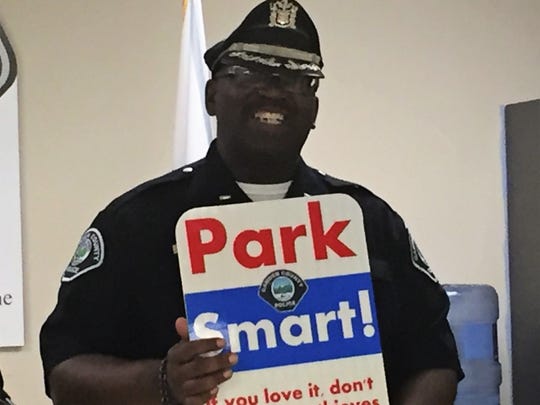 Camden Police Captain Zsakhiem James displays a sign urging city residents to protect themselves against car thieves and burglars.
