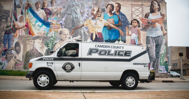 A Camden County Police vehicle travels past a mural located on Haddon Avenue in Camden on Monday, October 8, 2018.  