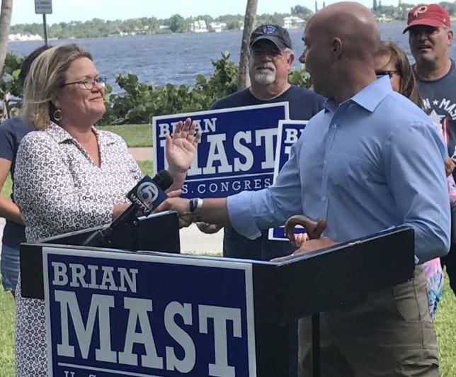 Kimberly Mitchell, left, executive director of the Everglades Trust, shakes hands Monday, Oct. 8, 2018, with U.S. Rep. Brian Mast after endorsing his re-election bid during a ceremony at Flagler Park in downtown Stuart.