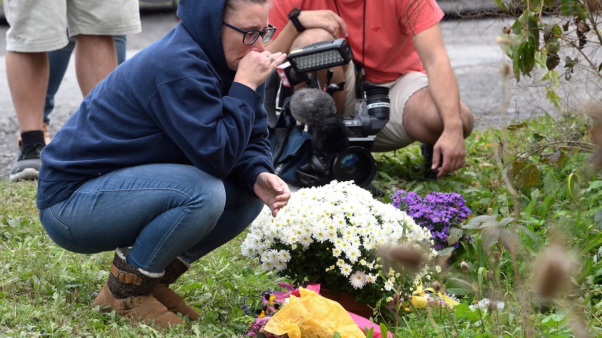 A woman takes a moment after placing flowers at the scene of the limousine crash. 