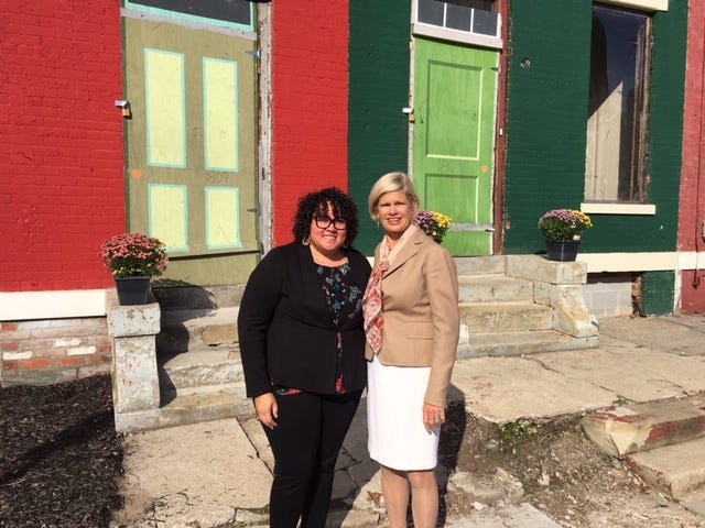 Seven Hills Neighborhood Houses' Tia Brown, Left, and Laura Brunner of The Port stand outside row houses planned  for redevelopment in the West End.