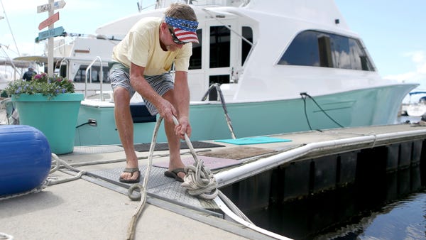 Rob Docko ties a knot while securing his boat at...