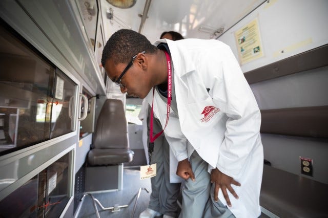 Lanier High student Chrishuan Williams inspects a retired AMR ambulance that has been donated to the school.