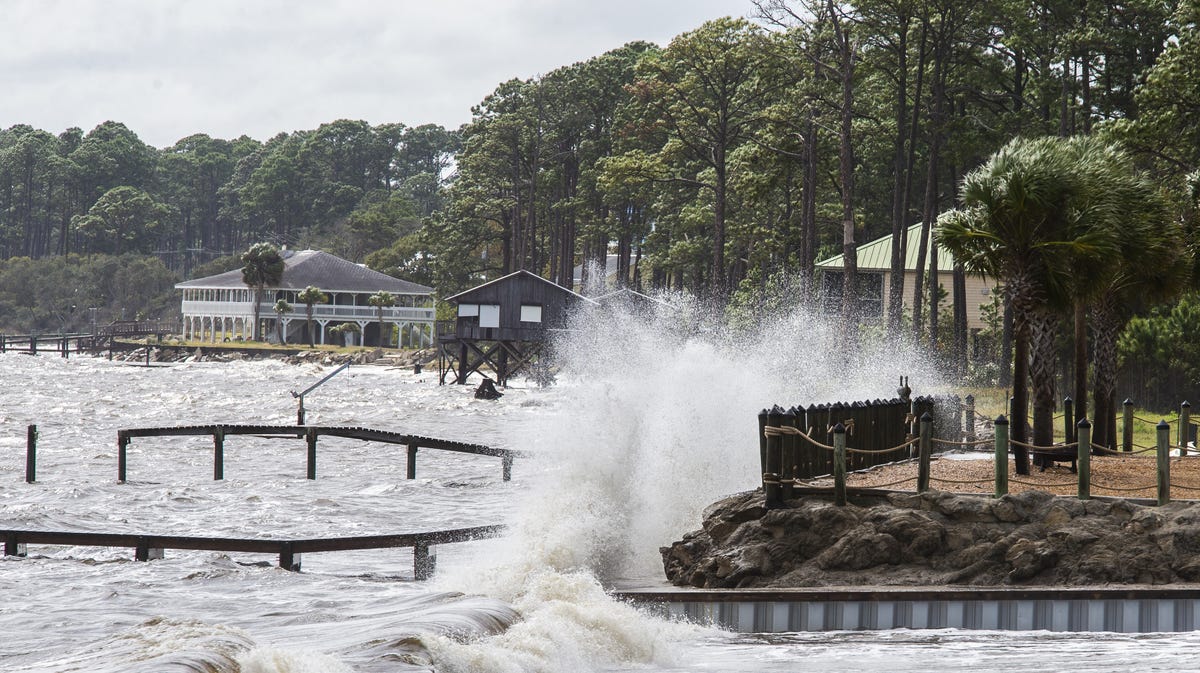 Waves crash against a home seawall as the surge starts pushing the tide higher as Hurricane Michael approaches on October 9, 2018 in Eastpoint, Florida.