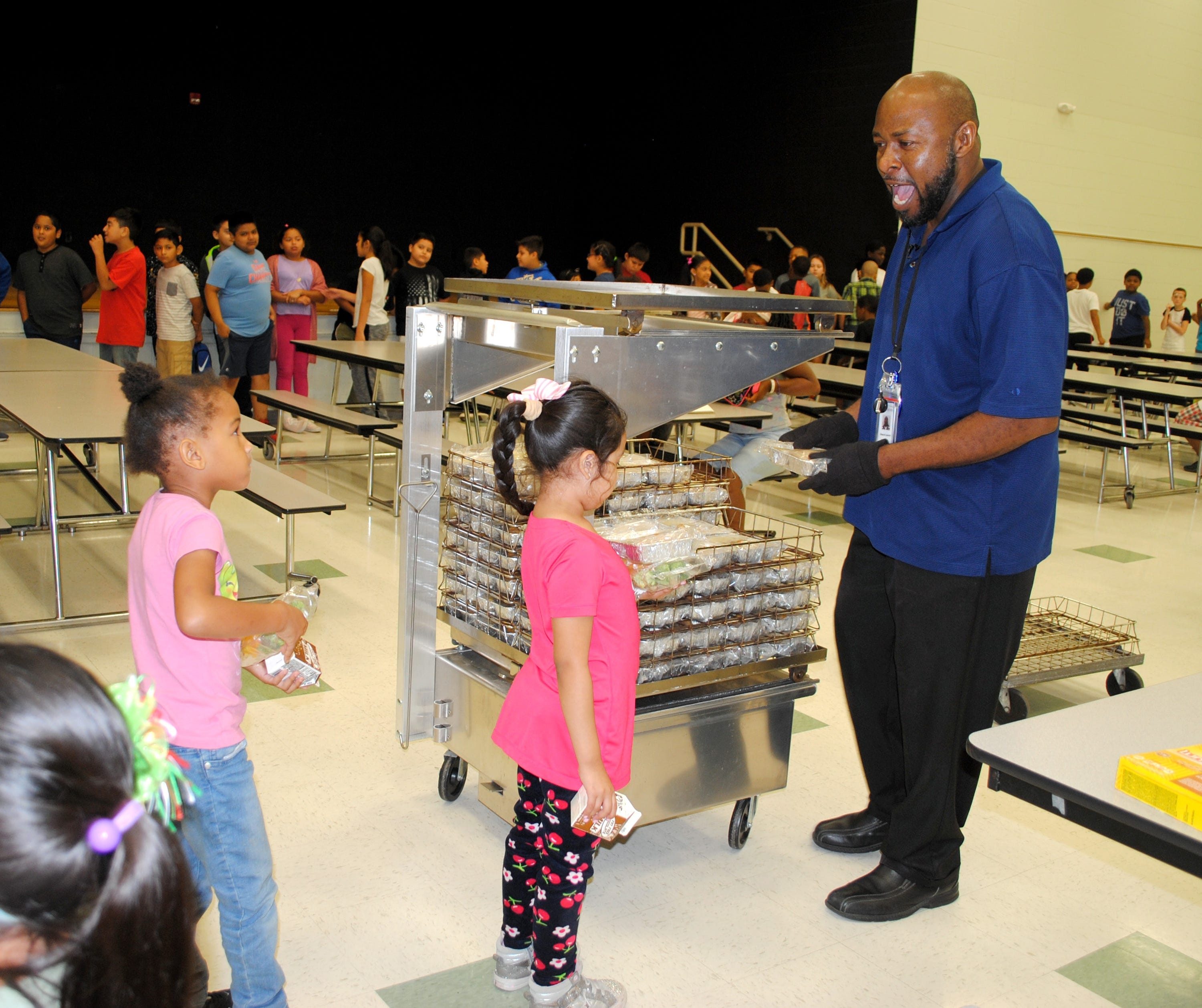 Edward Lawson, a full-time substitute teacher at Julian Thomas Elementary School in Racine, Wis., reacts with a smile to a student as he hands out lunches. Lawson has been with the Racine Unified School district for the past 18 years. He's different from a regular substitute; he works every day at the same school, and often does whatever needs to be done, from teaching a class to washing a poor student's dirty coat in the washing machine in his office.