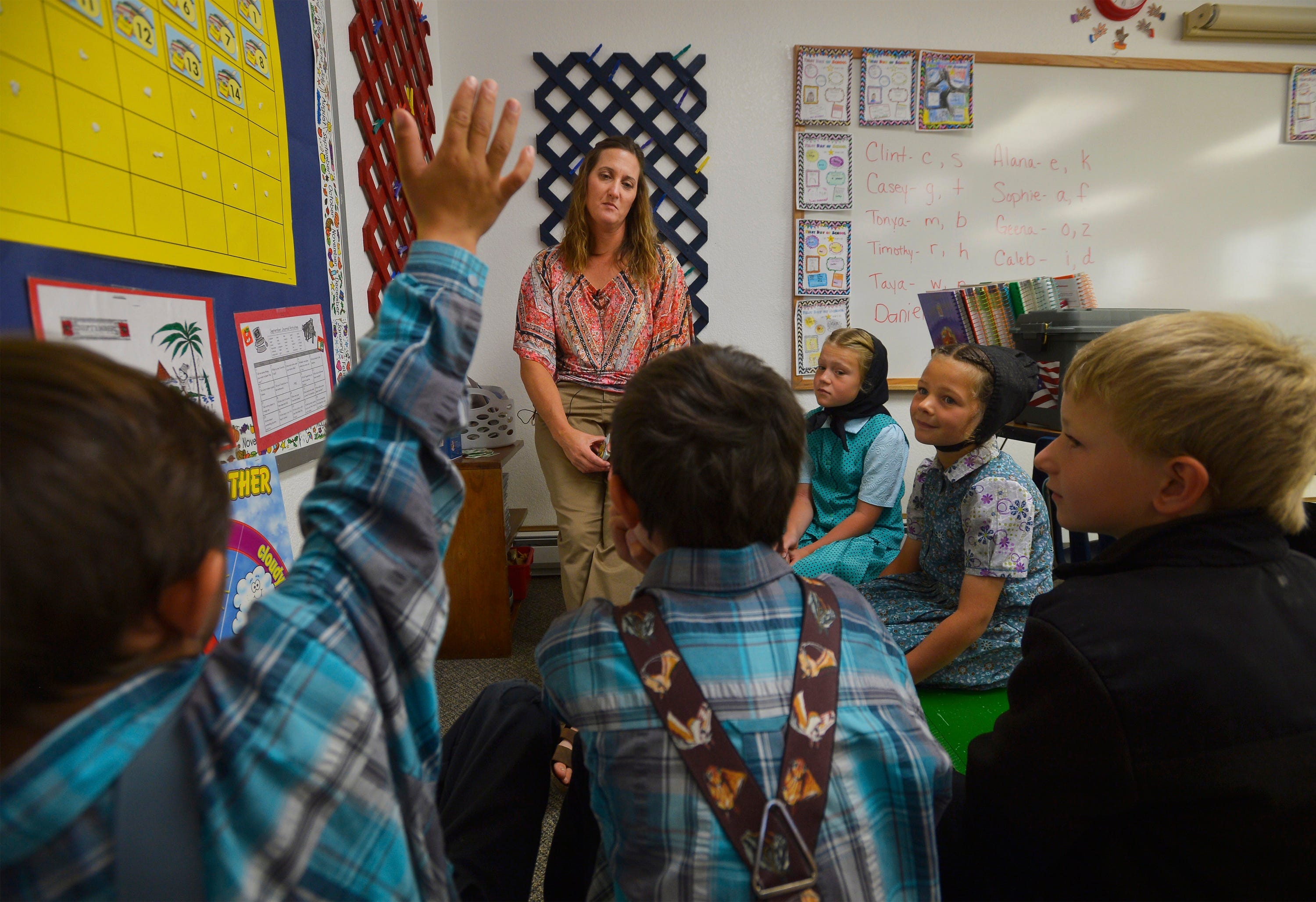 Traci Manseau leads her younger students in a lesson on days of the week.