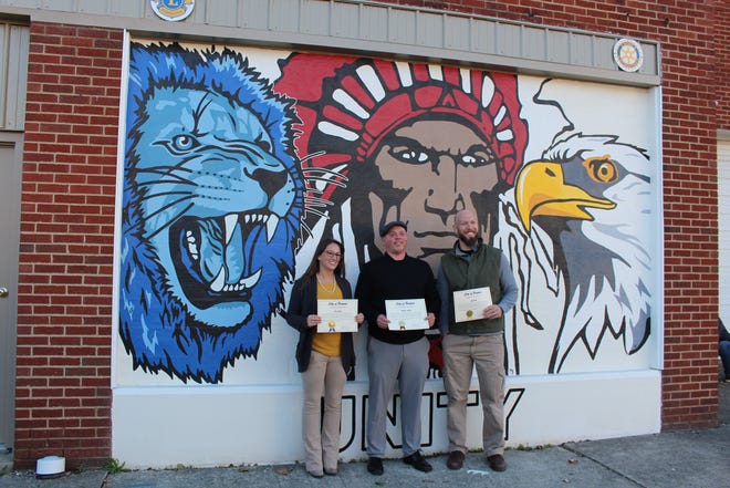 Wynford art teacher Erin Duffy, Bucyrus art teacher Michael Striker and Colonel Crawford art teacher Zac Bauer, from left, stand in front of the city's Community Unity mural on Thursday. The teachers and students from the three districts designed and painted the mural.