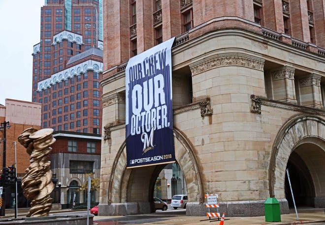 Large Brewers playoff banner hanging on Milwaukee City Hall.