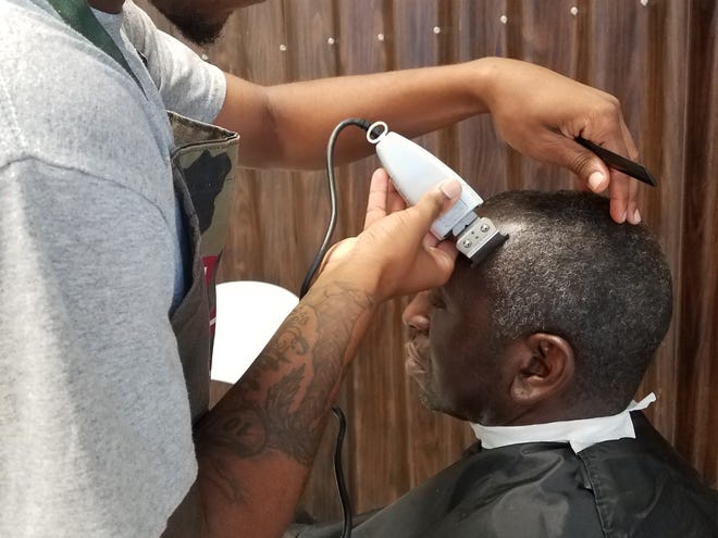 Rod Williams is the custodian of Walker-Ford Community Center, here being trimmed by Derrick Pete. Williams has come to the center each week for a year and a half.
