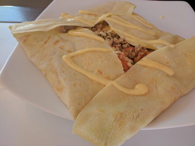 The sausage tomato crepe at La Crepe de France in Melbourne includes spicy pork sausage sauteed with sun-dried tomatoes, shallots and parsley. Two eggs and shredded mozzarella cheese were added before the crepe was folded up and drizzled with hollandaise sauce.