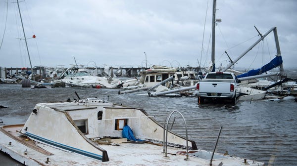 Damaged boats and a truck are seen in a marina...