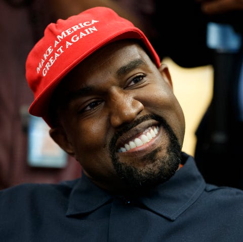 Rapper Kanye West smiles as he listens to a...