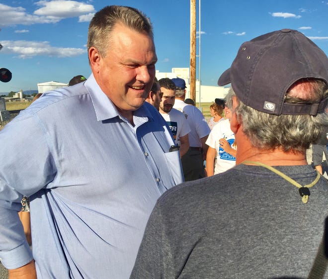 Sen. Jon Tester talks to a man at a union rally on Labor Day in Three Forks.