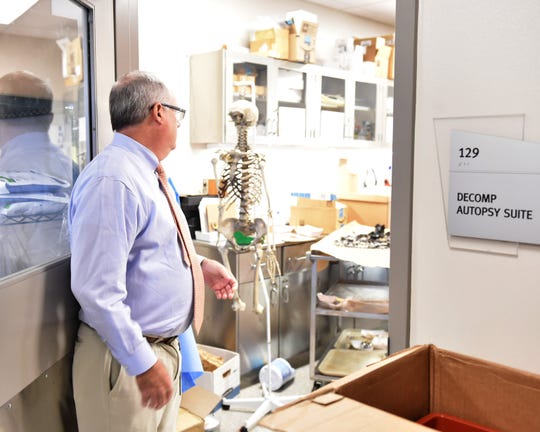 In October 2018 photo, Mississippi Forensic Lab Director Sam Howell looks in on an autopsy suite where forensic anthropologists work.