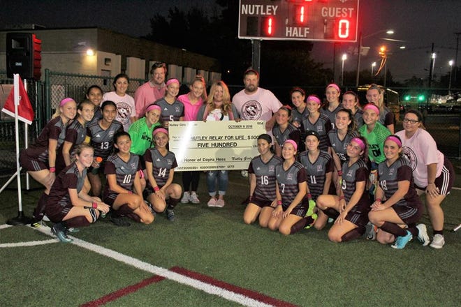 Nutley girls soccer team, with Hess family in middle, presenting check to Relay for Life.