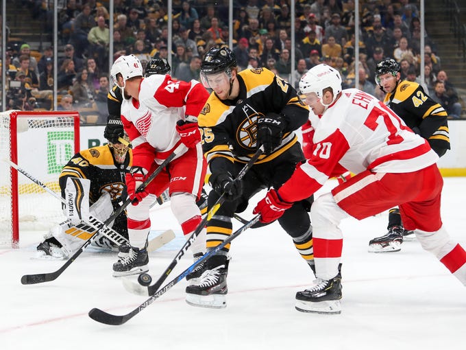 Bruins defenseman Brandon Carlo and Red Wings center Christoffer Ehn play for the puck during the first period on Saturday, Oct. 13, 2018, in Boston.