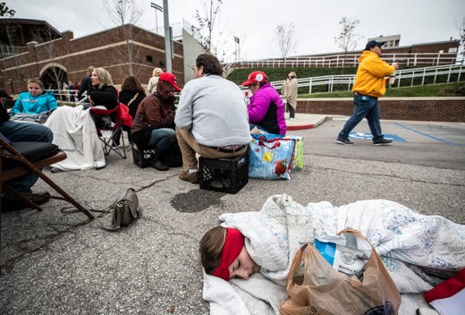Seventeen-year-old Lexi Lockard sleeps wrapped up in a blanket in a parking lot outside the Alumni Coliseum for the speech of President Donald Trump Saturday night.