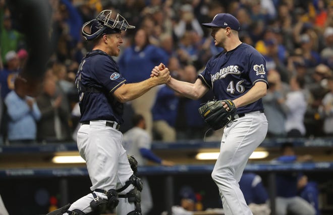 Brewers reliever Corey Knebel is congratulated by Erik Kratz after Knebel struck out Justin Turner of the Dodgers to give Milwaukee a 6-5 win in Game 1 of the NLCS on Friday night at Miller Park.
