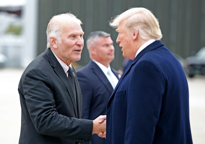 Ohio District 1 Congressman Steve Chabot shakes hands with President Donald Trump after he exits Air Force One at Lunken Airport in Cincinnati on Friday, Oct. 12, 2018.