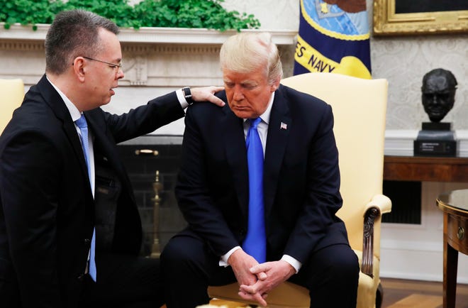 President Donald Trump prays with American pastor Andrew Brunson in the Oval Office of the White House, Saturday October 13, 2018, in Washington. Brunson returned to the U.S. around midday after he was freed Friday, from nearly two years of detention in Turkey.