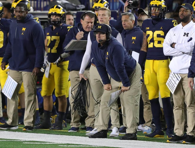Michigan coach Jim Harbaugh (center) and offensive line coach Ed Warinner (left with the headset) watch the second half against Wisconsin on Saturday, Oct. 13, 2018 at Michigan Stadium in Ann Arbor.