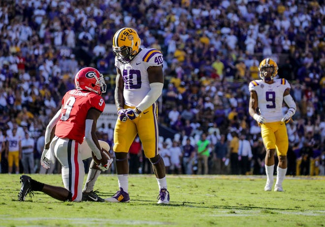 LSU Tigers linebacker Devin White and Georgia Bulldogs wide receiver Jeremiah Holloman during the second quarter at Tiger Stadium.