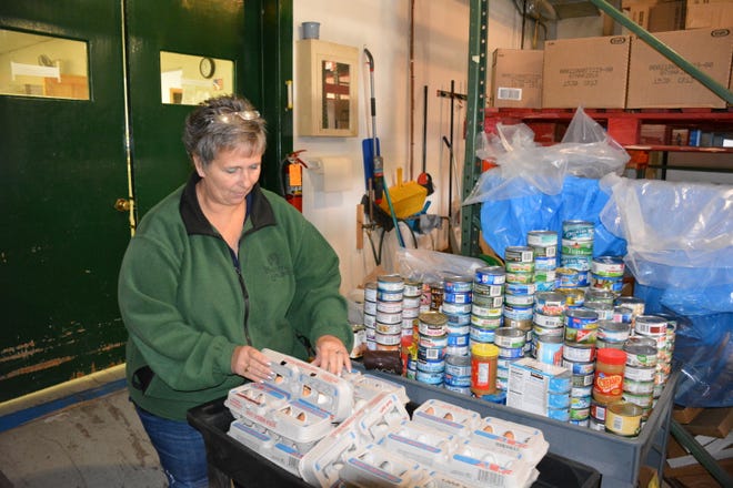 Amy Kinnard, food pantry manager at Lakeshore CAP in Sturgeon Bay, inventories donations.